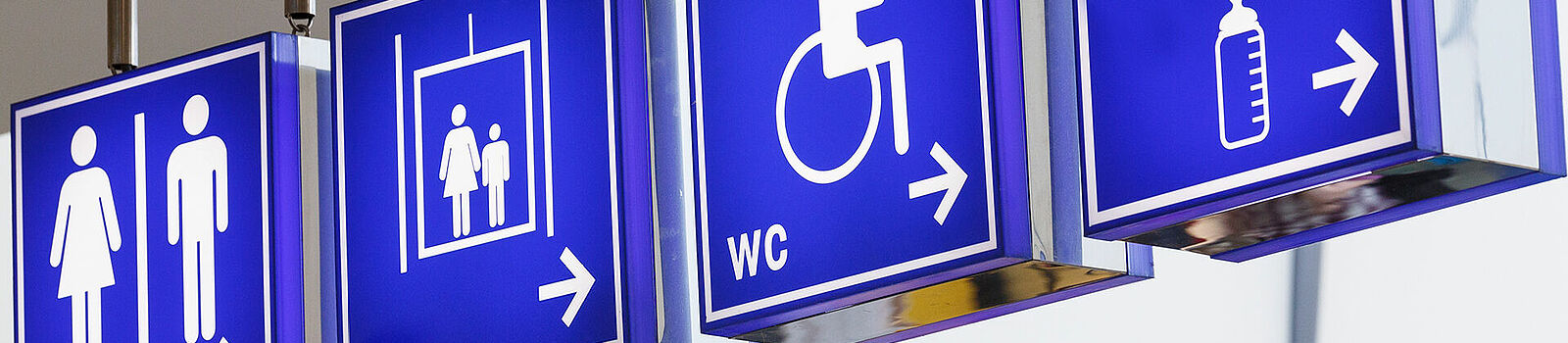 Mehrere blaue Wegweiser mit Pfeilen, die in unterschiedliche Richtungen weisen.